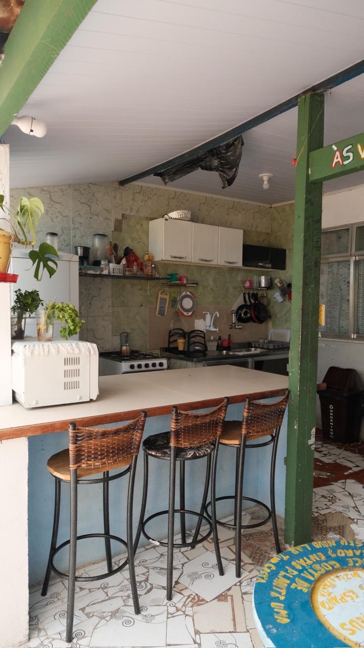 The shared kitchen in the co-living space, with a breakfast bar, stools, cupboards and plants.