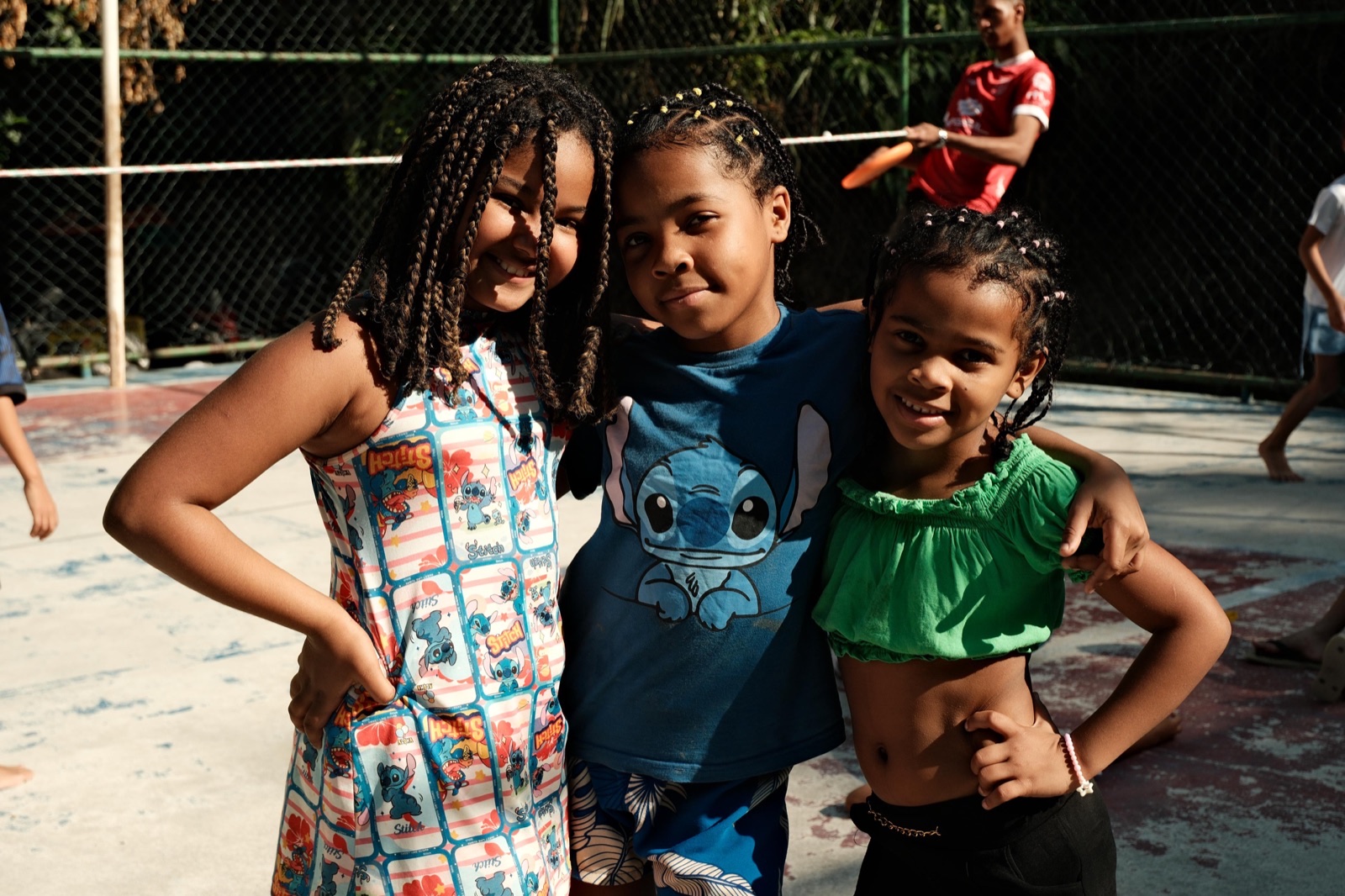 Three girls pose together, laughing, at one of our activities.