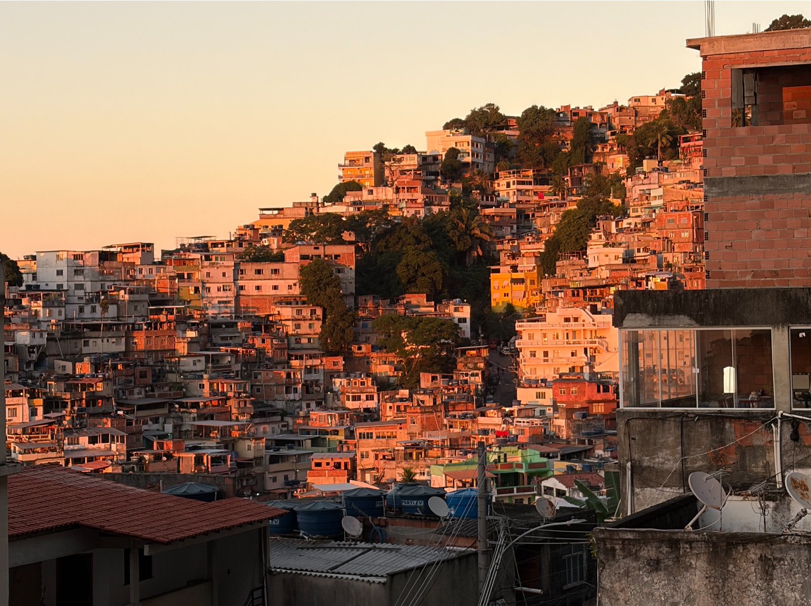 The houses of Vidigal climbing the hillside, lit orange by the evening sun.